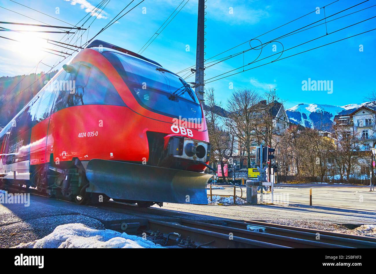 ZELL AM SEE, Österreich - 28. FEBRUAR 2019: Die modernen roten Zug fährt die Zebrastreifen in der Altstadt, am 28. Februar in Zell am See Stockfoto