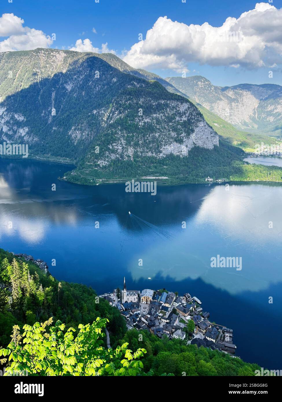 Malerische Berglandschaft mit einem ruhigen See, malerischem Dorf, hellem Grün und einer friedlichen Atmosphäre. Betonung auf natürliche Schönheit, Sere Stockfoto