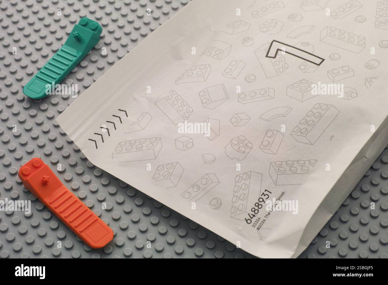 Tambow, Russische Föderation - 22. Juni 2024 Lego Pieces Papiertüte mit Nummer 1 und zwei Ziegeltrennern auf einer grauen Grundplatte Stockfoto