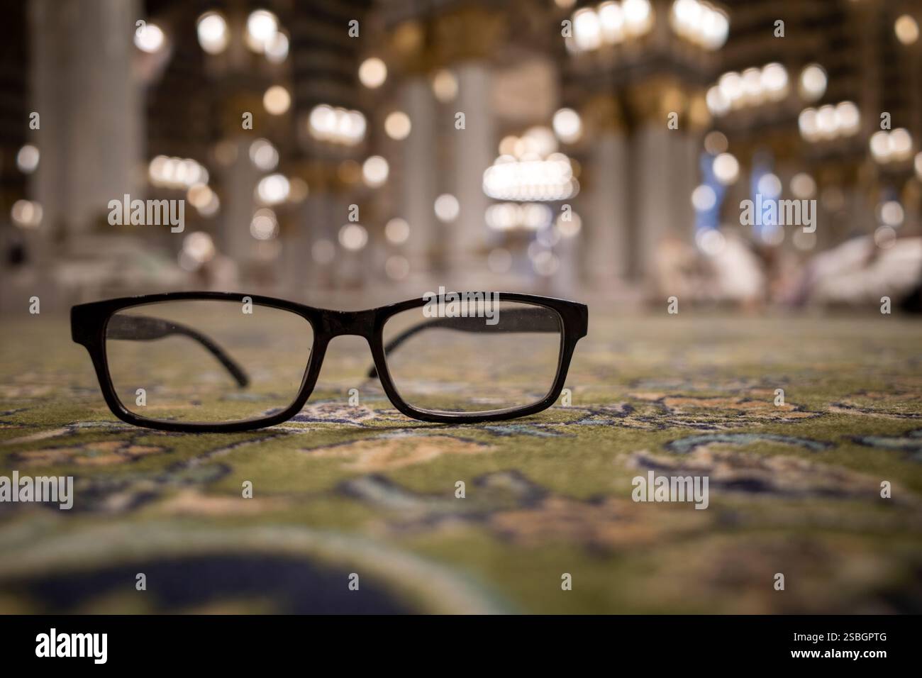 Eine schwarze Brille auf dem grünen Teppich in der Prophet Moschee, Masjid Nabawi in Madina, Saudi Arabien. Stockfoto Eine schwarze Brille auf dem grünen Teppich in der Prophet Moschee, Masjid Nabawi in Madina, Saudi Arabien. Stockfoto
