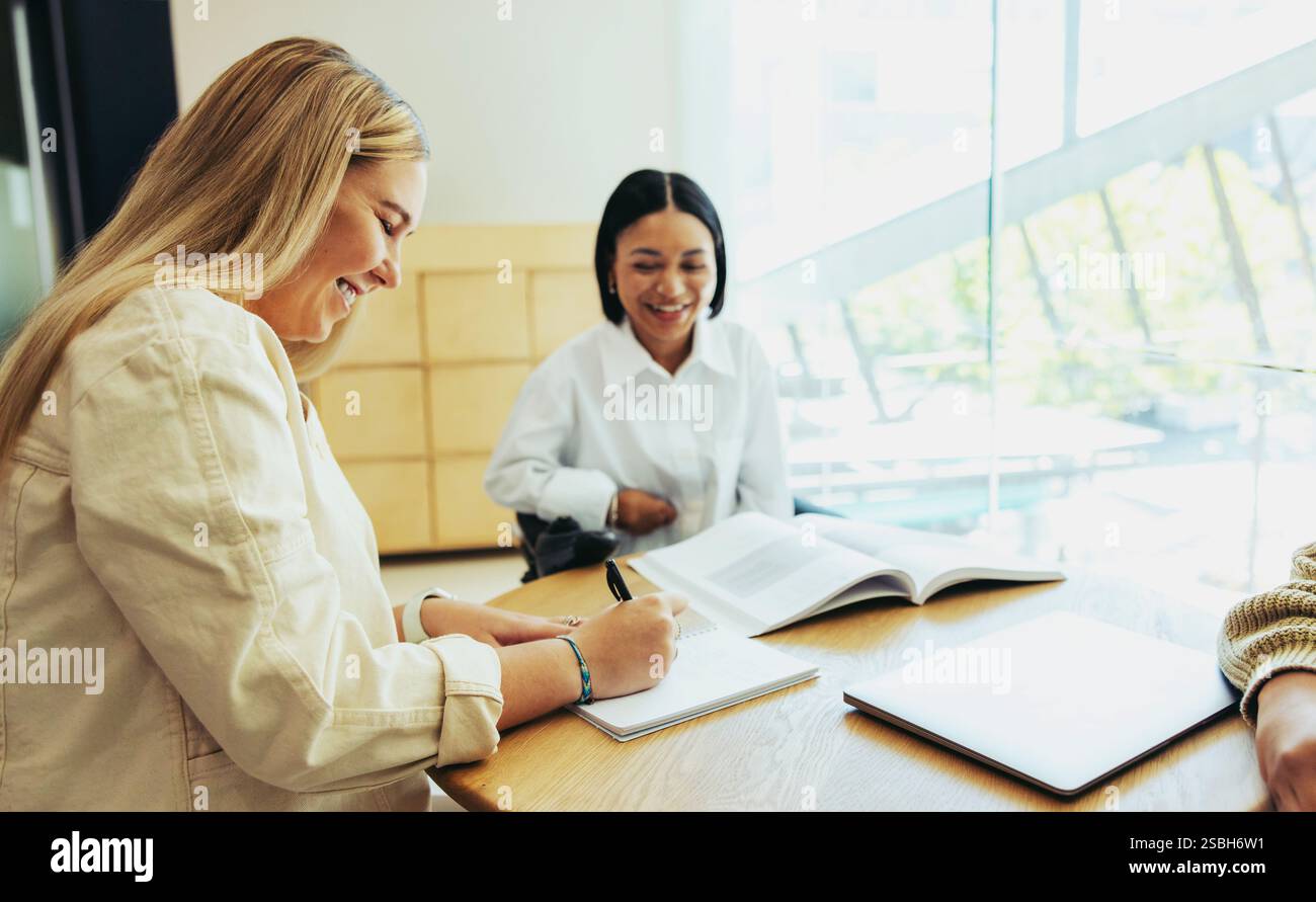 Eine vielfältige Gruppe von Schülern, die glücklich in einer städtischen Schule lernen. Dieses Bild zeigt Bildung, Zusammenarbeit und eine positive Lernatmosphäre Stockfoto