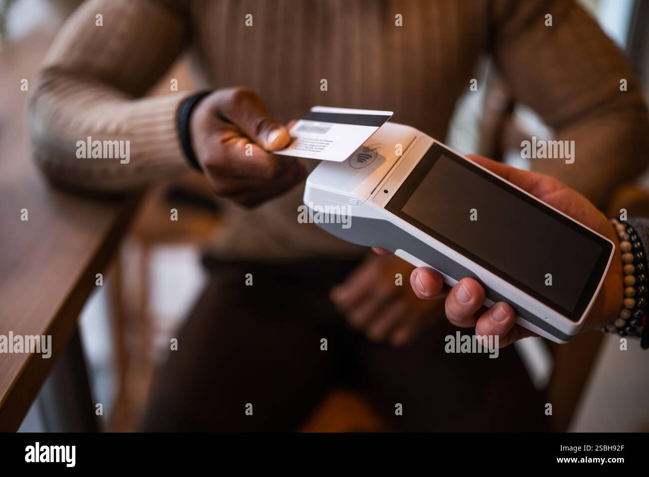 Nahaufnahme von Mann bezahlt kontaktlos mit Kreditkarte in der Bar. Stockfoto
