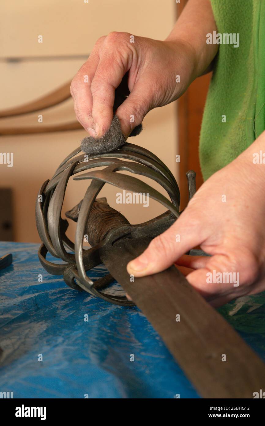 Die Restaurierung des alten Schwertes - Detail der Hand bei der Arbeit Stockfoto