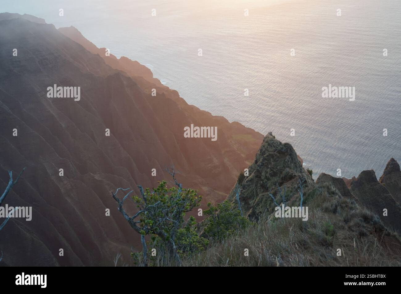 Atemberaubender Sonnenaufgang über der Na Pali Küste, Kauai. Dramatische Klippen treffen auf den Pazifik und schaffen eine atemberaubende tropische Landschaft. Stockfoto