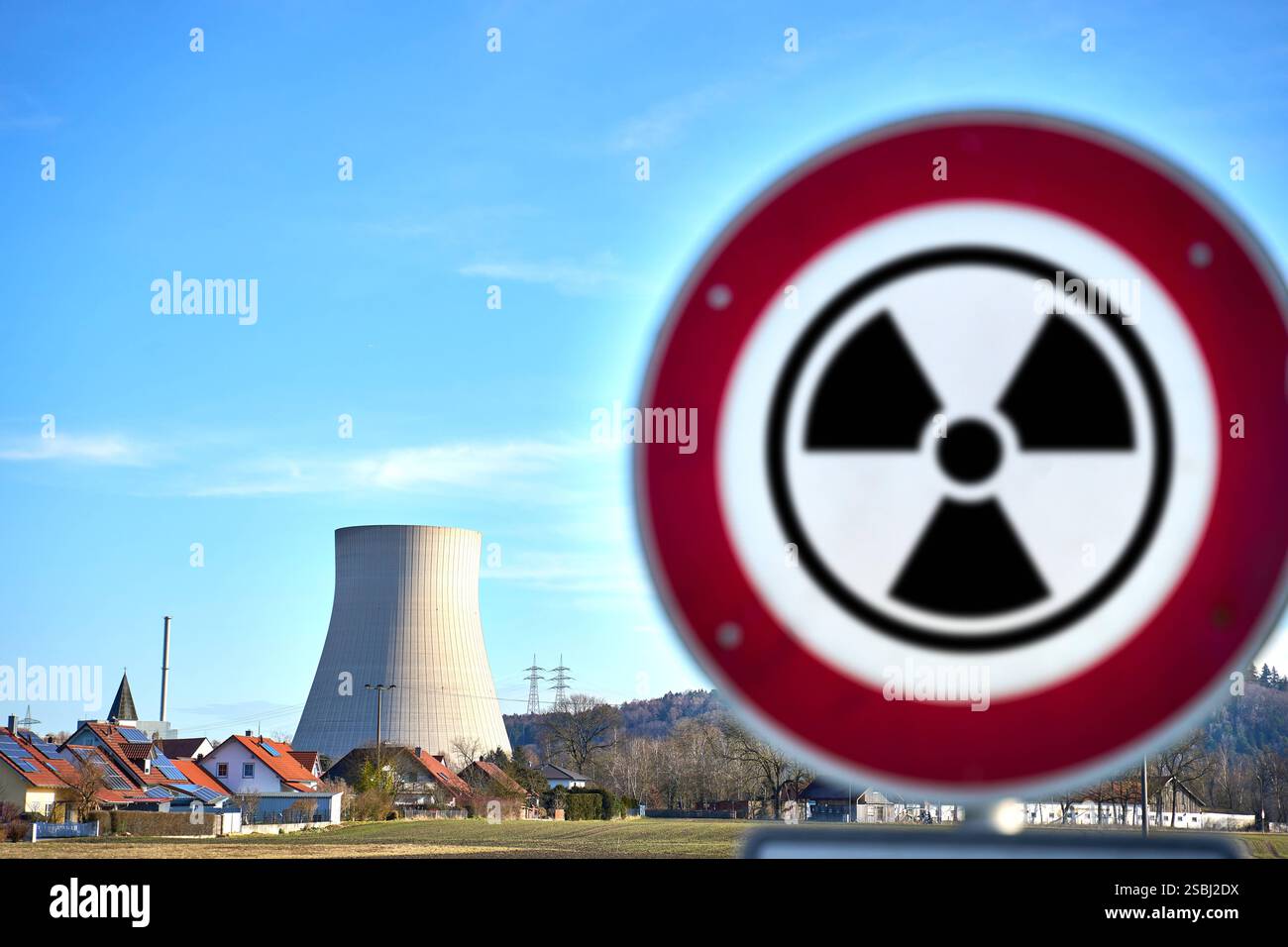 Essenbach, Bayern, Deutschland - 01. Februar 2025: FOTOMONTAGE, Ein Warnschild mit einem Strahlungssymbol vor einem Kernkraftwerk, symbolisiert die potenziellen Gefahren von Radioaktivität, Strahlenrisiken und die Gefahr von nuklearen Abfällen für Umwelt und Gesundheit. *** FOTOMONTAGE, ein Warnschild mit Strahlensymbol vor einem Atomkraftwerk symbolisiert die potenziellen Gefahren von Radioaktivität, Strahlenrisiken und die Bedrohung durch Atommüll für Umwelt und Gesundheit. Stockfoto