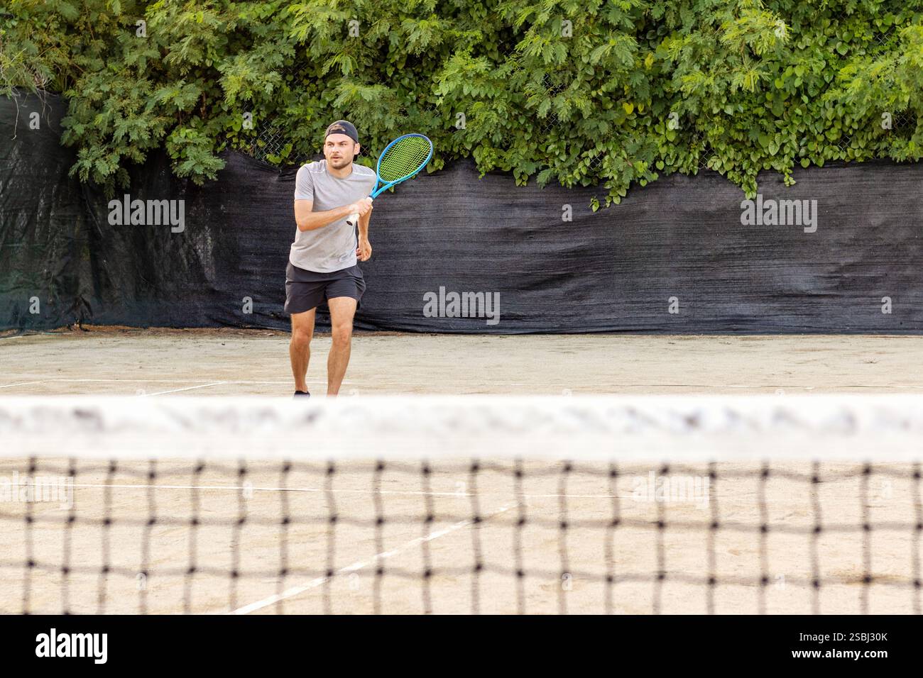 Männliches Sportlertraining für Tennis auf dem Freiluftplatz im Sommer Stockfoto