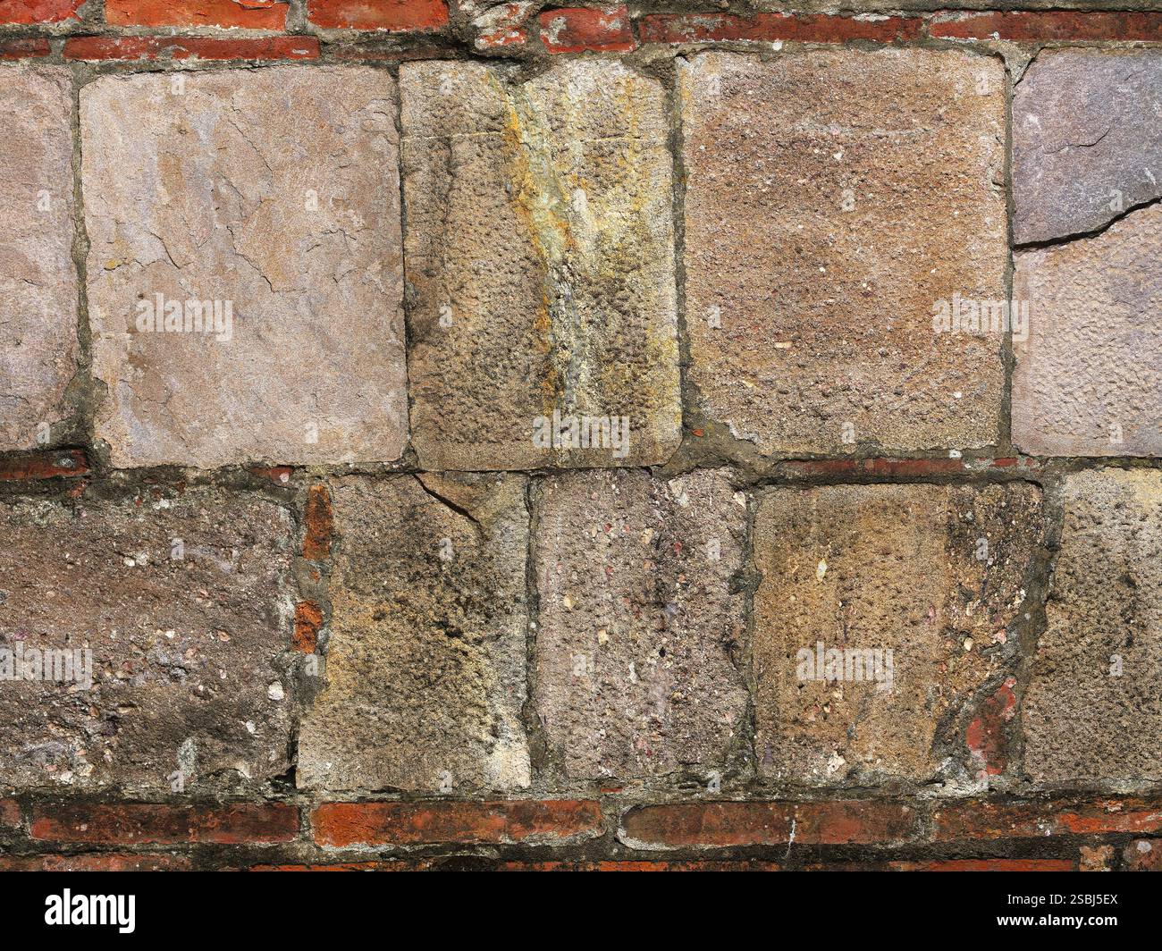 Alte Steinmauer mit roten Ziegeln als Hintergrund Stockfoto