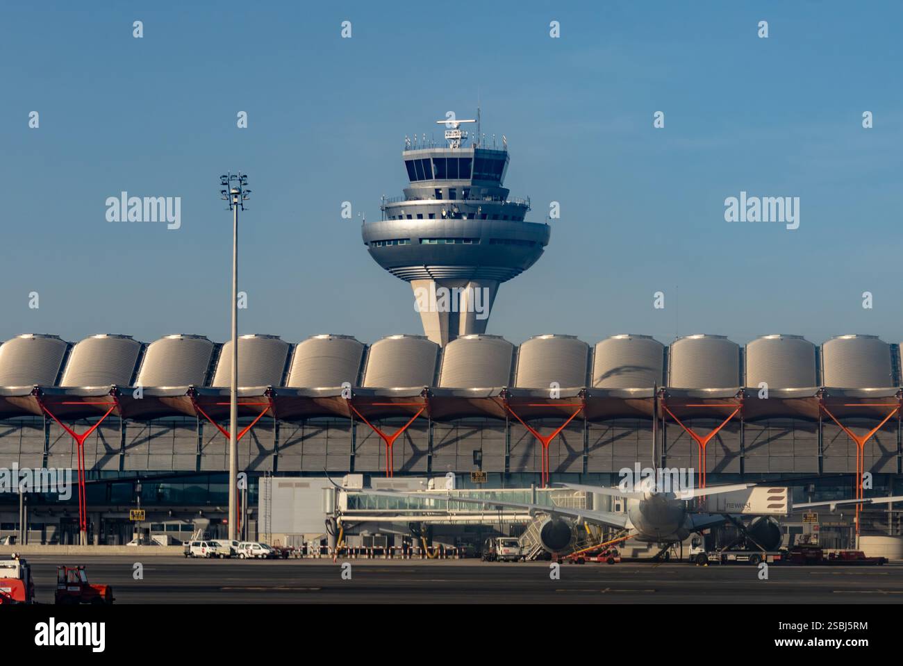 Terminal T4S, Kontrollturm und ein Jetliner am Flughafen Adolfo Suárez Madrid-Barajas, Madrid, Spanien. Stockfoto