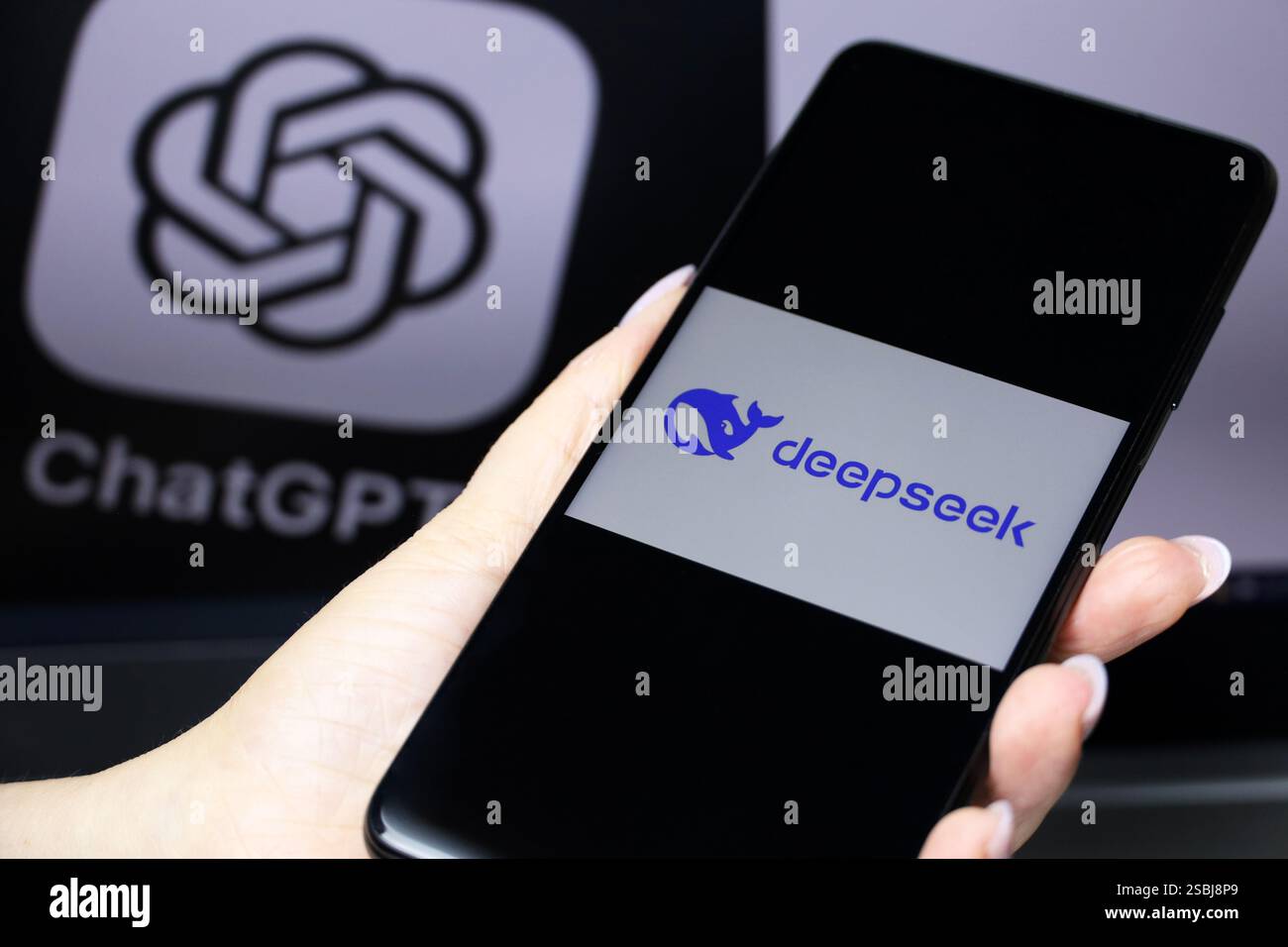DeepSeek Ai auf dem Smartphone-Bildschirm in weiblicher Hand und ChatGPT-Logo auf dem Computerdisplay Stockfoto
