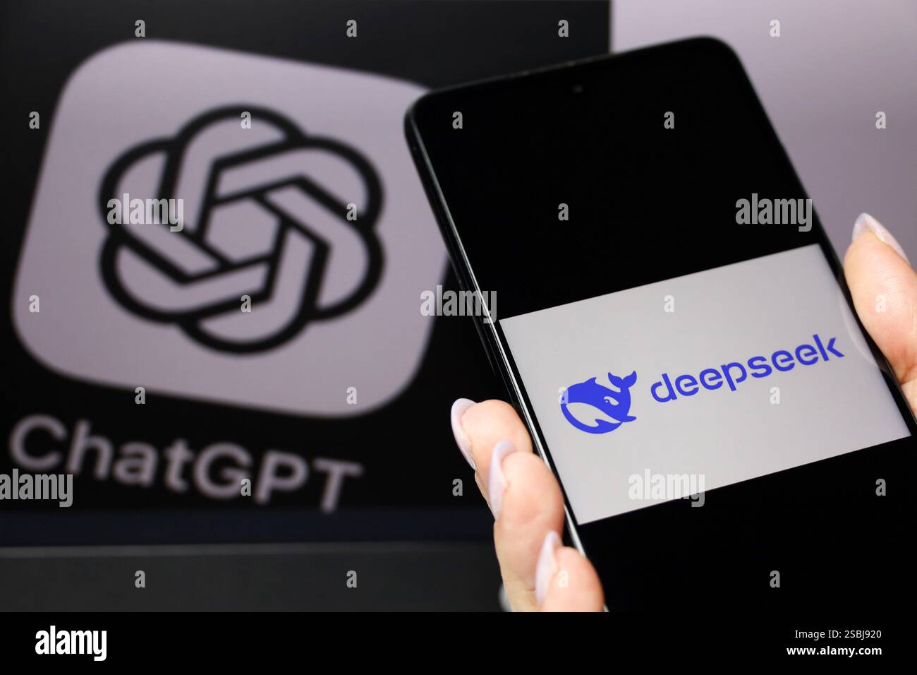 DeepSeek Ai auf dem Smartphone-Bildschirm in weiblicher Hand und ChatGPT-Logo auf dem Computerdisplay Stockfoto