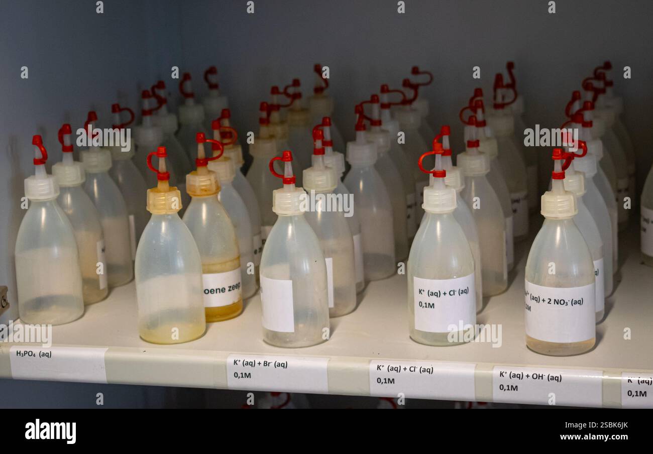 Kleine Tropfflaschen mit chemischen Substanzen in einem Schrank. Wird im Chemiekurs der High School verwendet. Stockfoto