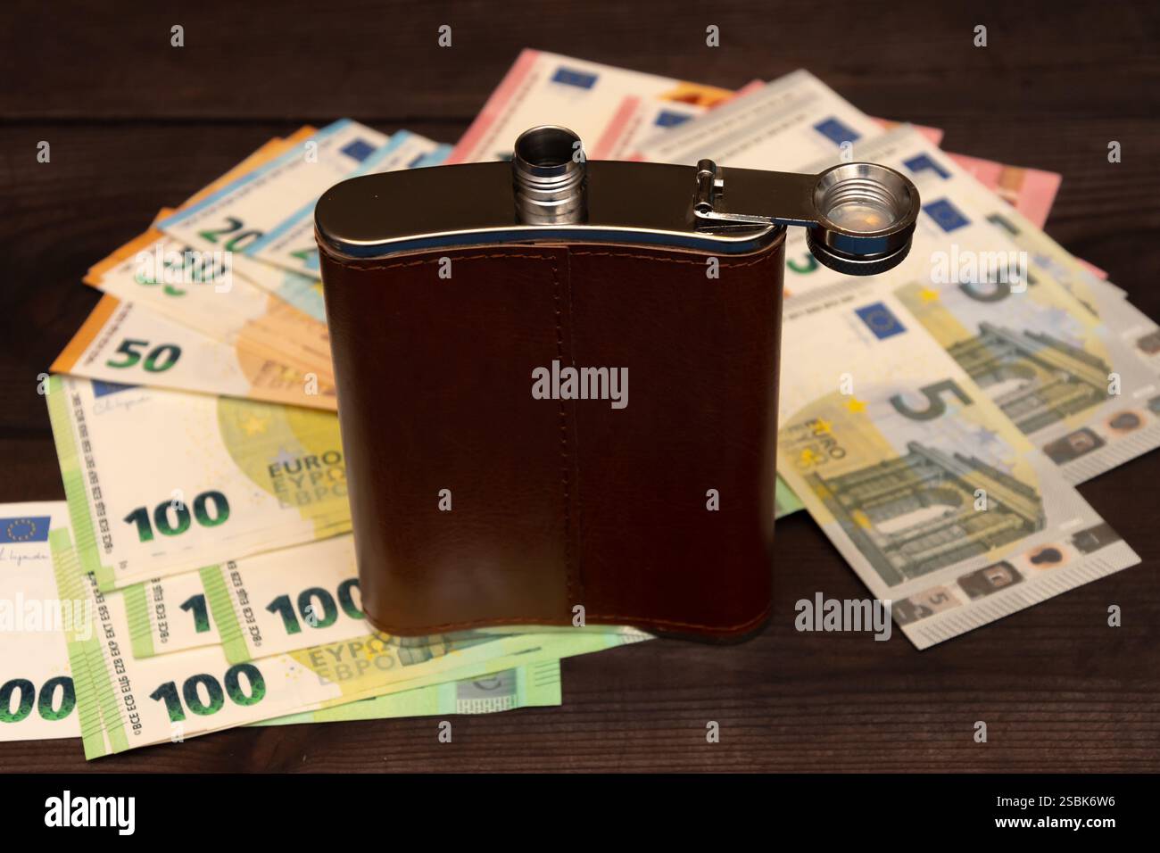 Ein Metallkolben vor dem Hintergrund von Euro-Banknoten ist ein Symbol für sucht und finanziellen Verlust Stockfoto