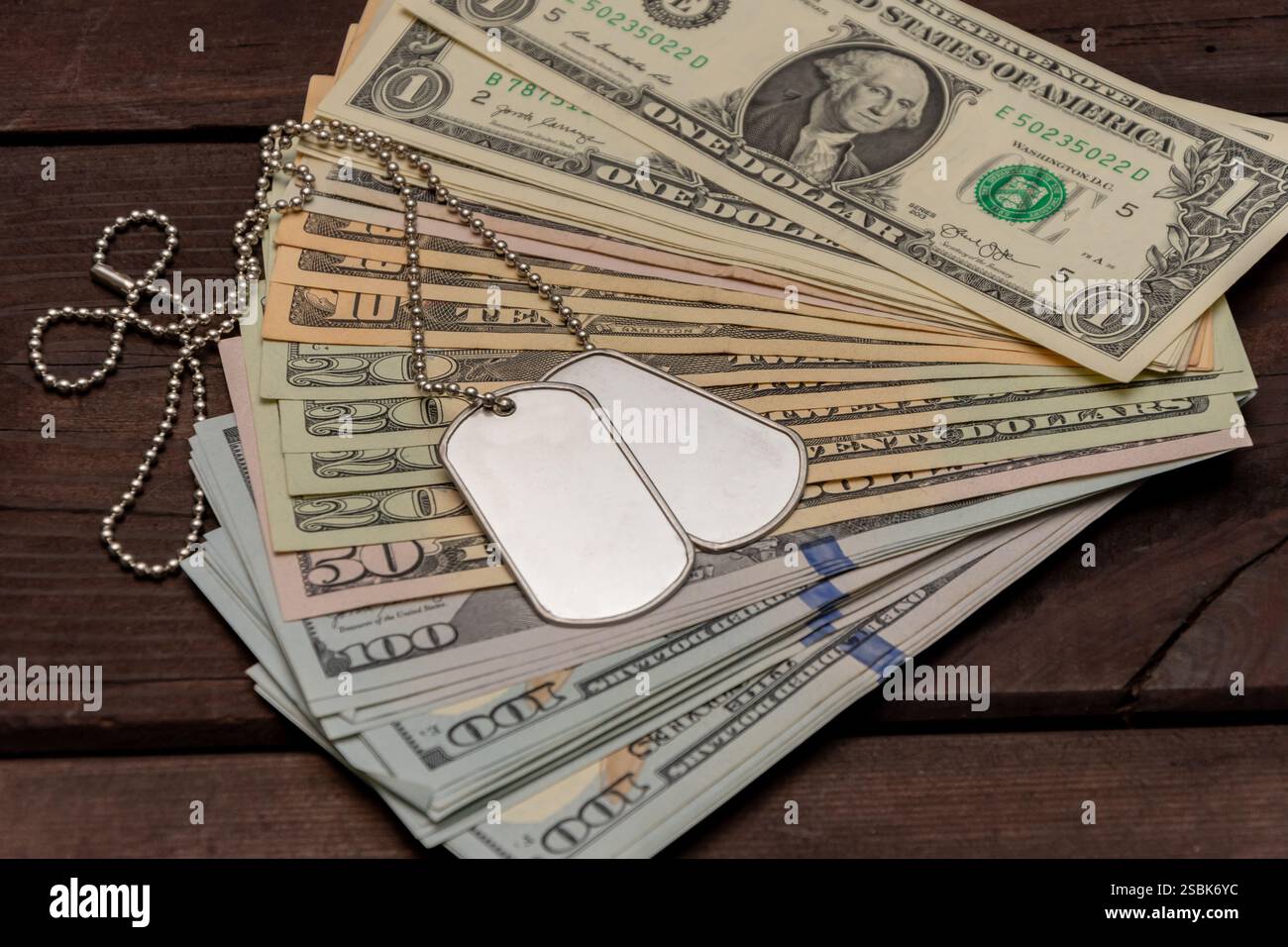 Ein Symbol für Militärdienst und finanzielle Unterstützung, das Zeichen des Soldaten unter den US-Rechnungen Stockfoto