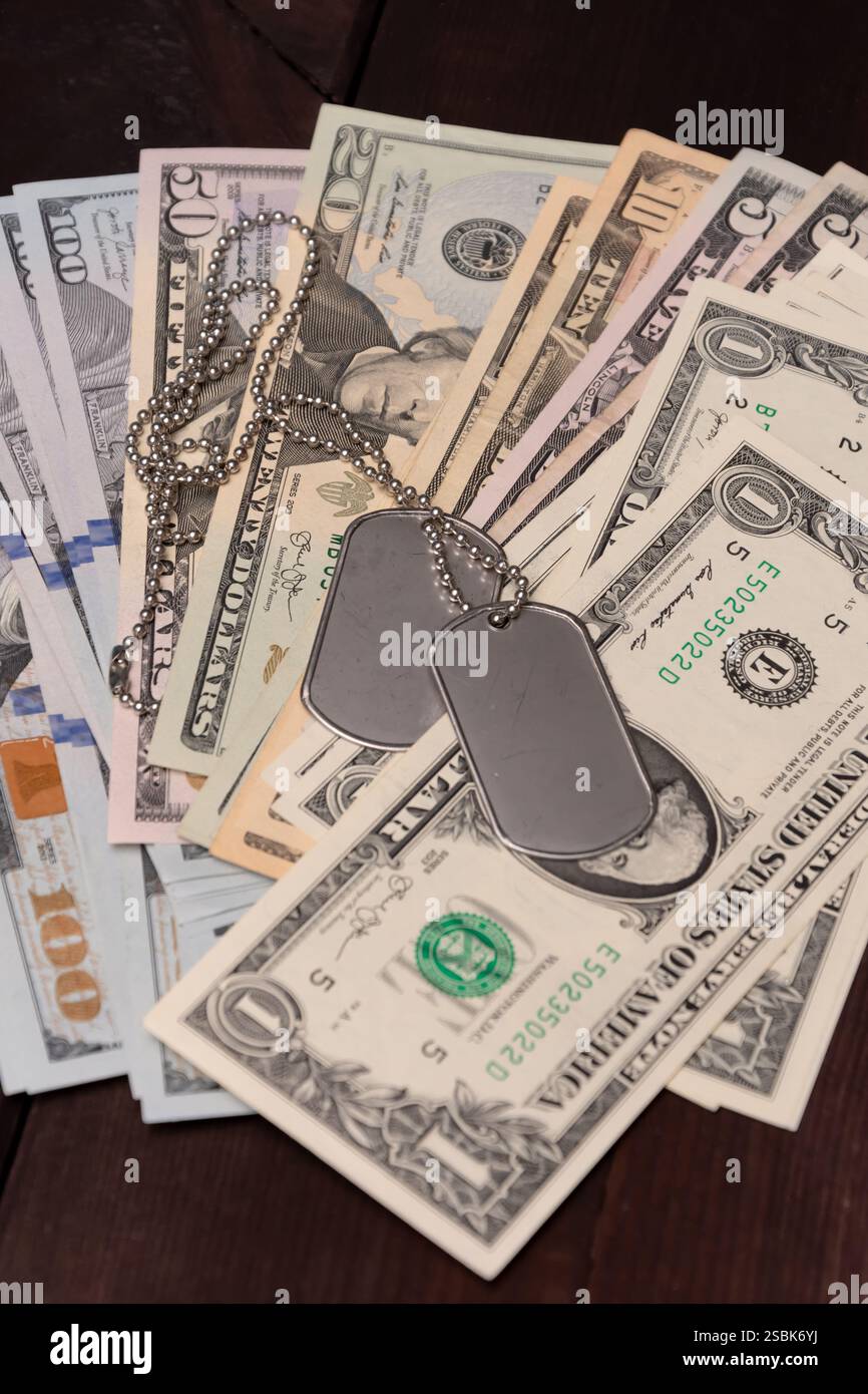 Die Metallmarke gegen die Währung spiegelt die Kosten für Militärdienst und Sozialleistungen wider Stockfoto