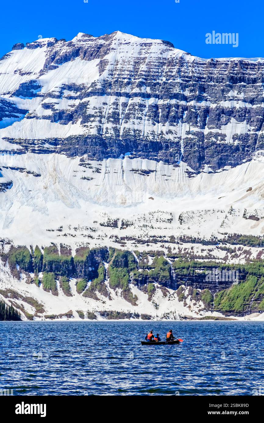 Eine Gruppe von Menschen sitzt in einem Boot auf einem See. Das Boot ist mitten im See und die Leute tragen Schwimmwesten Stockfoto