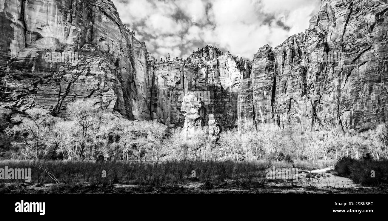 Bergkette mit einem großen Felsen in der Mitte. Der Felsen ist von Bäumen umgeben. Der Himmel ist bewölkt Stockfoto