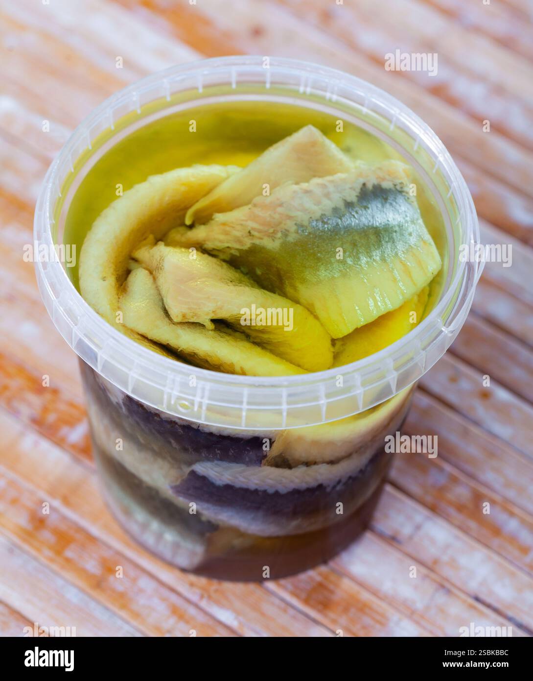 In Kunststoffbehältern befinden sich große Stücke gesalzenen Heringsfilet, die von Knochen befreit sind Stockfoto