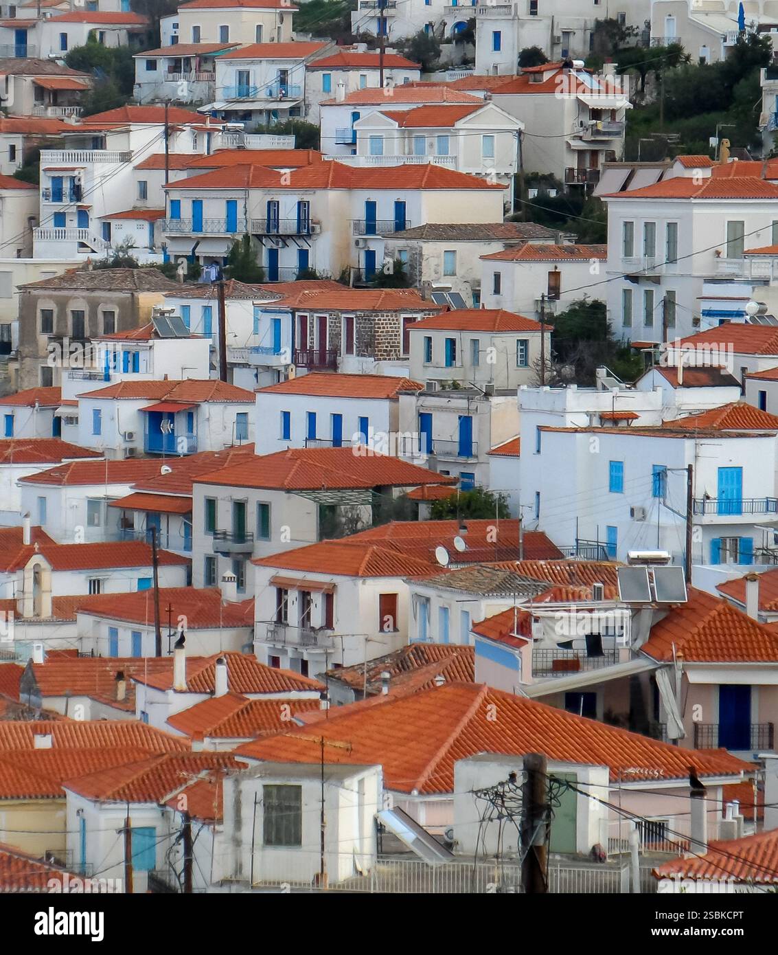 Nahaufnahme weißer Häuser mit blauen Fenstern und Türen und orangefarbenen Dächern auf einer griechischen Insel im Mittelmeer Stockfoto