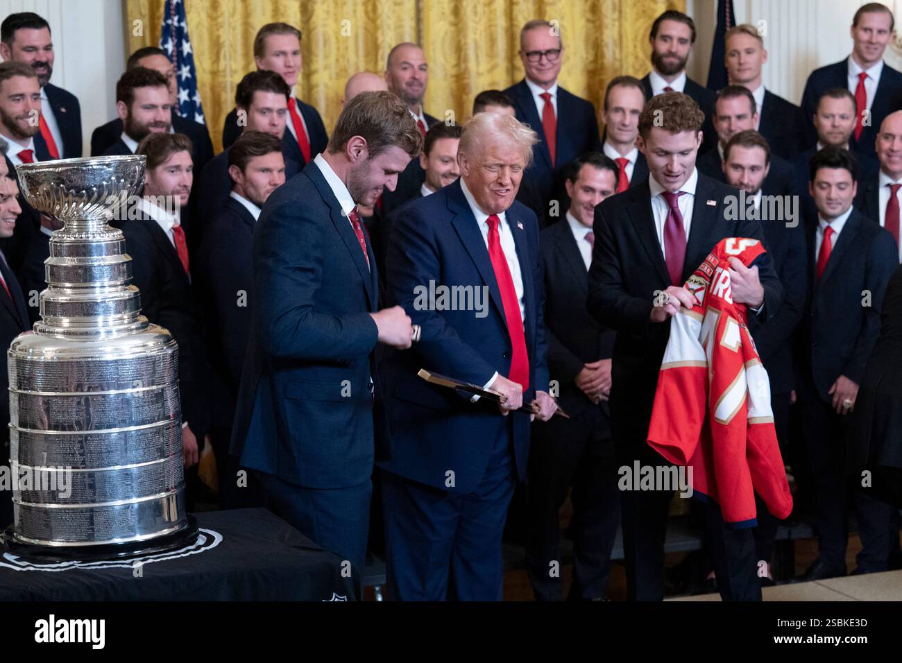 Washington, Usa. Februar 2025. US-Präsident Donald J Trump erhält vom Mannschaftskapitän Aleksander Barkov (L) und dem Flügelspieler Matthew Tkachuk vom Stanley Cup der National Hockey League, der die Florida Panthers im Weißen Haus in Washington, DC, gewann, 3. Februar 2025 einen vergoldeten Hockeyschläger und ein Mannschaftstrikot. Credit: Chris Kleponis/Pool via CNP Credit: Abaca Press/Alamy Live News Stockfoto