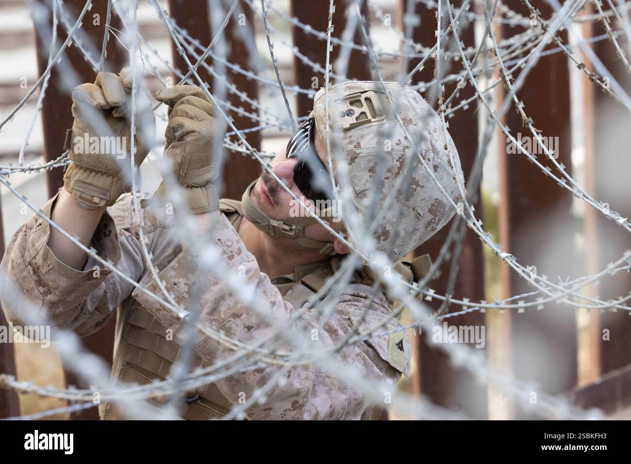 Ein US-Marine mit 1. Kampfingenieur-Bataillon, 1. Marine-Division, sichert den Draht entlang der südlichen Grenzmauer in der Nähe von San Ysidro, Kalifornien, 27. Januar 2025. Das U.S. Northern Command arbeitet mit dem Department of Homeland Security zusammen, um physische Barrieren zu errichten, um zusätzliche Sicherheit zu schaffen, die illegale Grenzübertritte einschränken wird. (Foto des U.S. Marine Corps von Lance CPL. Caleb Goodwin) Stockfoto