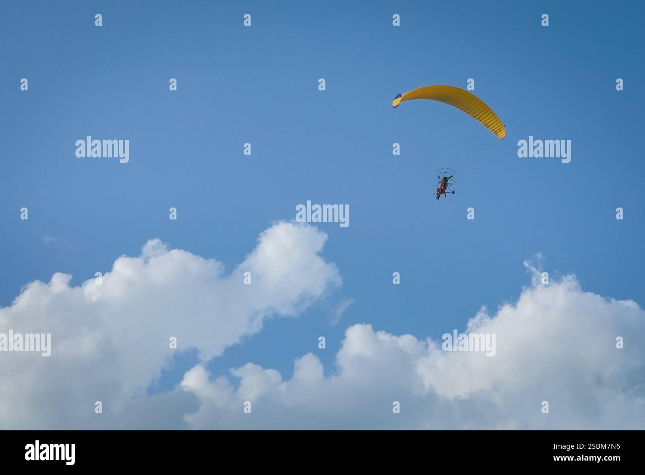 Der Paramotor fliegt im blauen Himmel. Flachwinkelansicht. Stockfoto