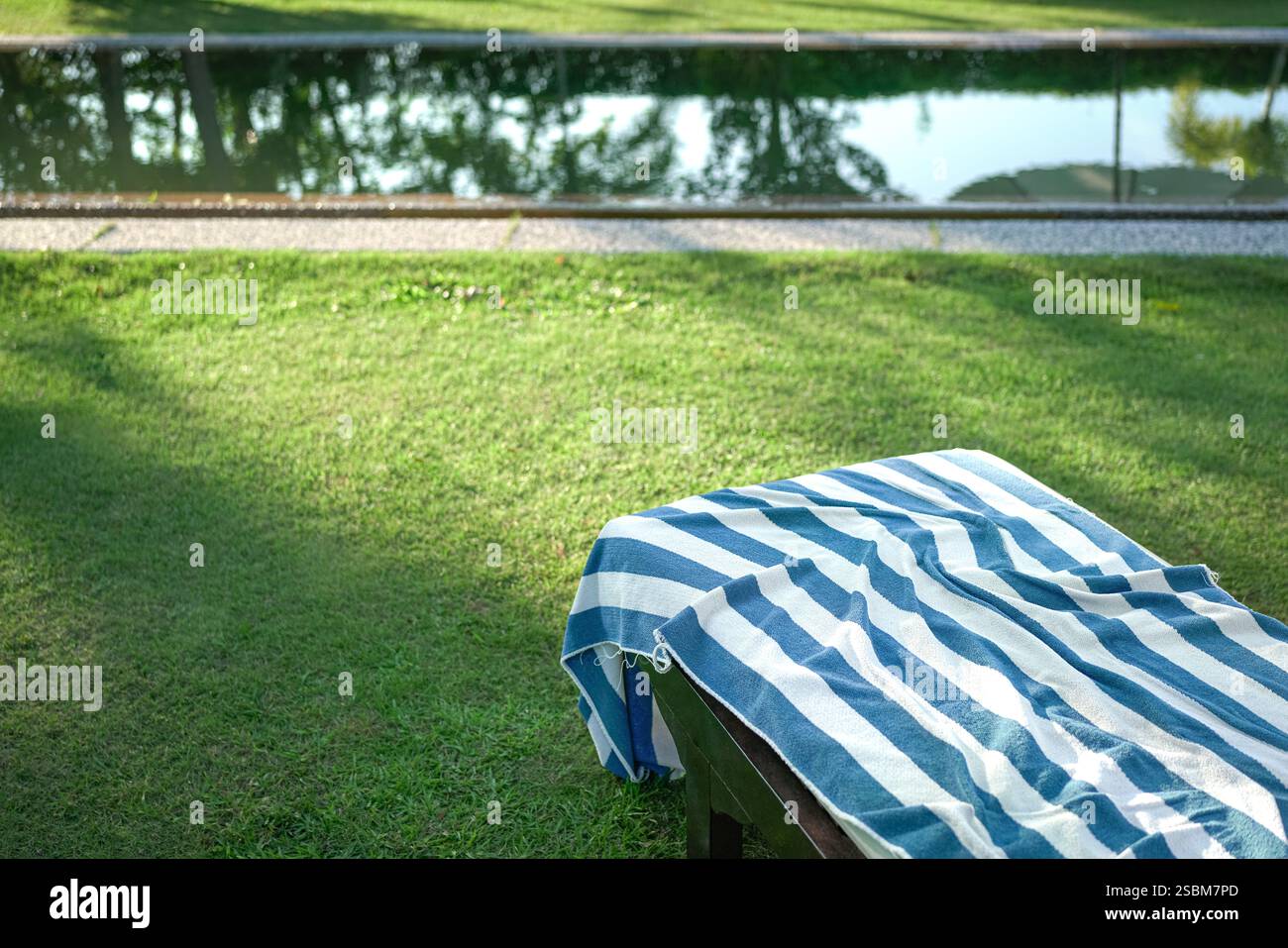 Poolhandtuch auf einem Liegestuhl. Urlaubs- oder Freizeitkonzept. Stockfoto