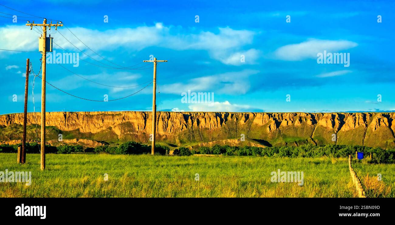 Drahtstange mit einem blauen Kasten darüber. Der Pfosten ist in einem Feld. Es gibt zwei weitere Pole im Feld Stockfoto