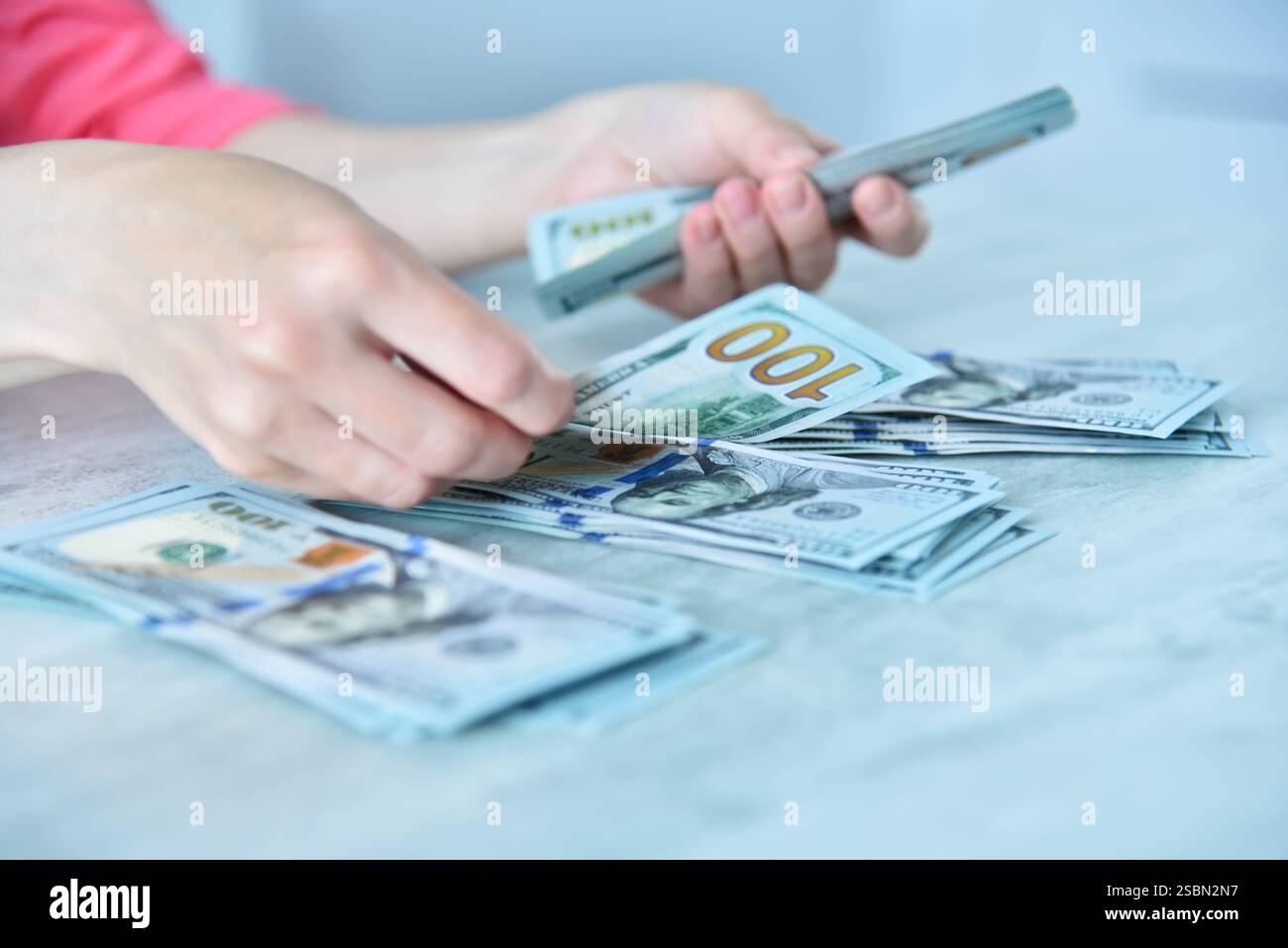 Geschäftsfrau Hands arrangiert Dollar in drei Stapel auf dem Tisch. Korruptions- und Bestechungskonzept. Nahaufnahme Stockfoto