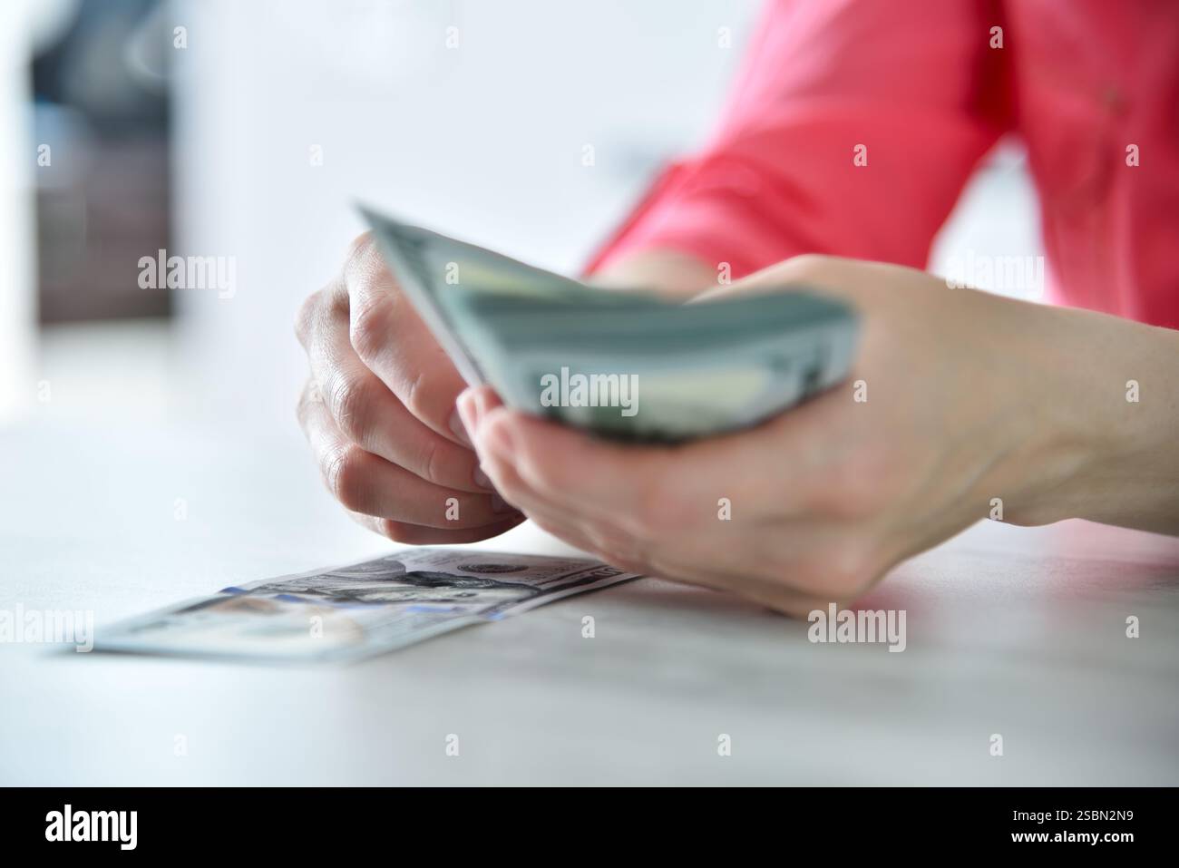 Frau, die am Tisch Dollar zählt. Finanzieller Erfolg und Geschäftskonzept. Nahaufnahme Stockfoto