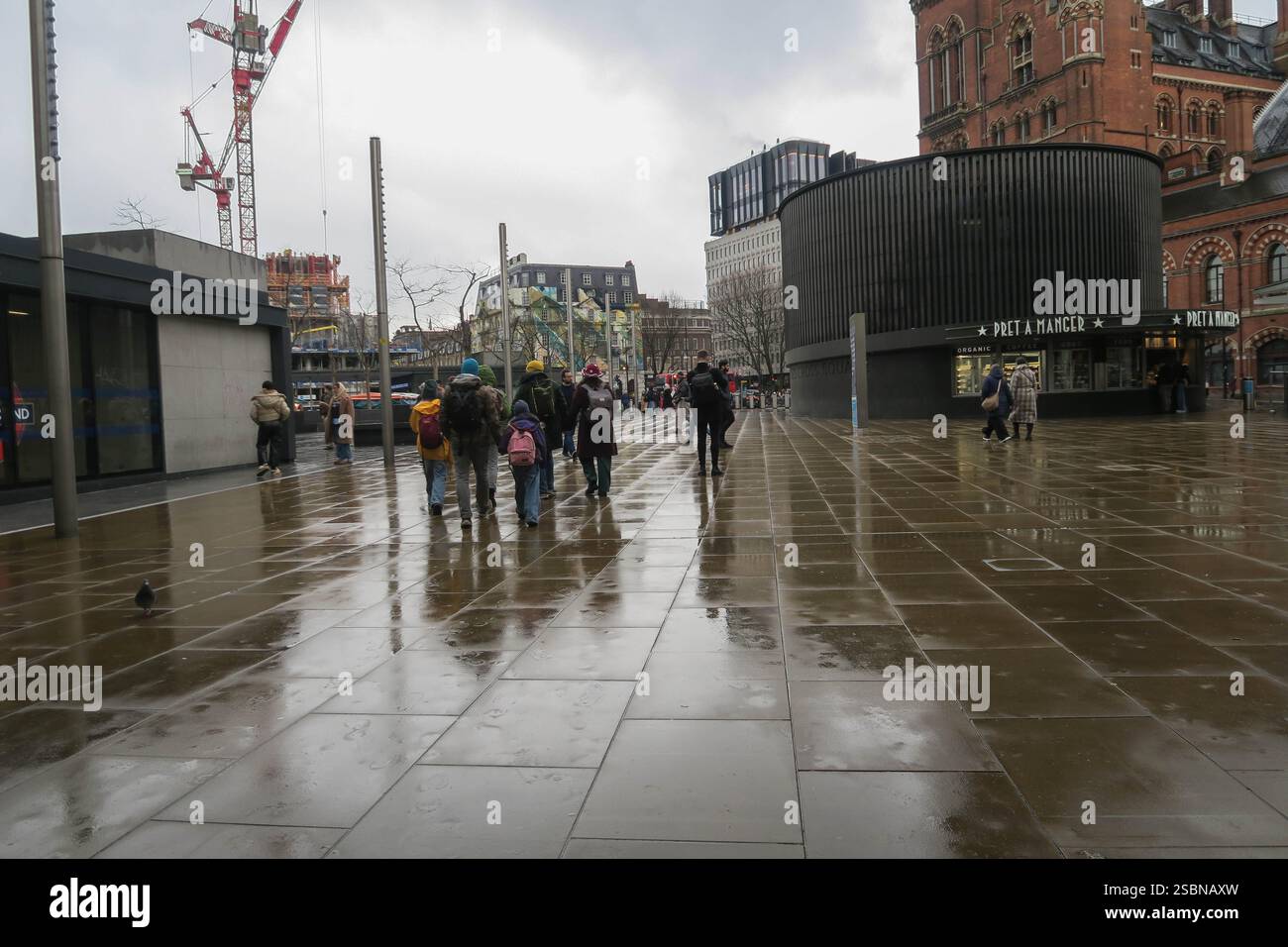 Eine Familie von Tagesausflüglern vor der Kings Cross Station an einem regnerischen Januarmorgen Stockfoto