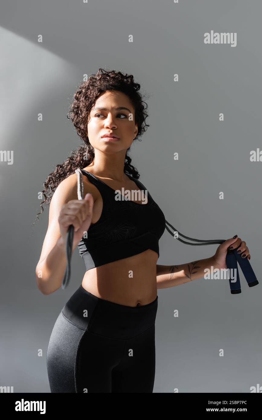 Eine entschlossene Frau trainiert in einem modernen Fitnessstudio mit Widerstandsbändern und zeigt ihre Stärke. Stockfoto