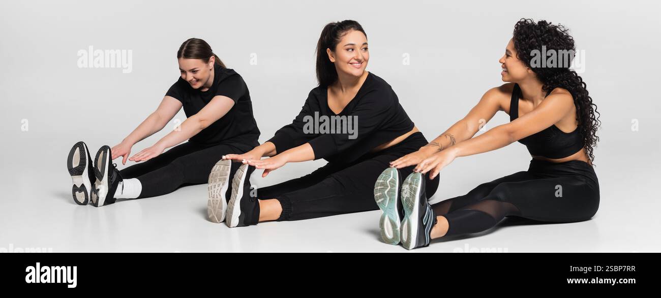 Starke und fitte Frauen führen eine Stretching-Routine durch und zeigen ihre Sportlichkeit und Einheit. Stockfoto