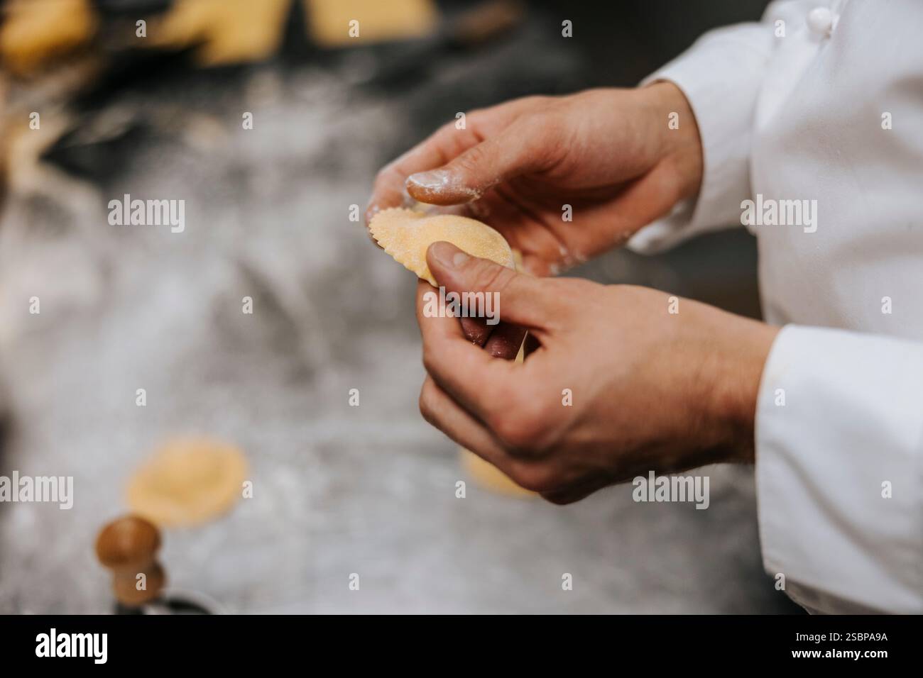 Männlicher Koch, der im Restaurant Knödel macht Stockfoto