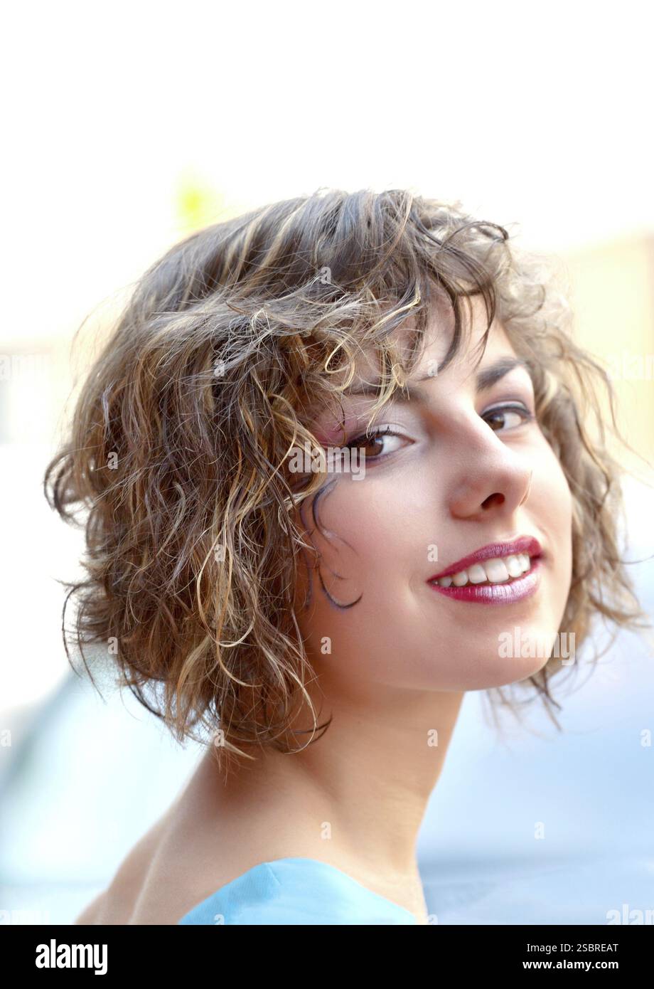 Porträt einer schönen jungen Frau lächelnd im Freien Stockfoto