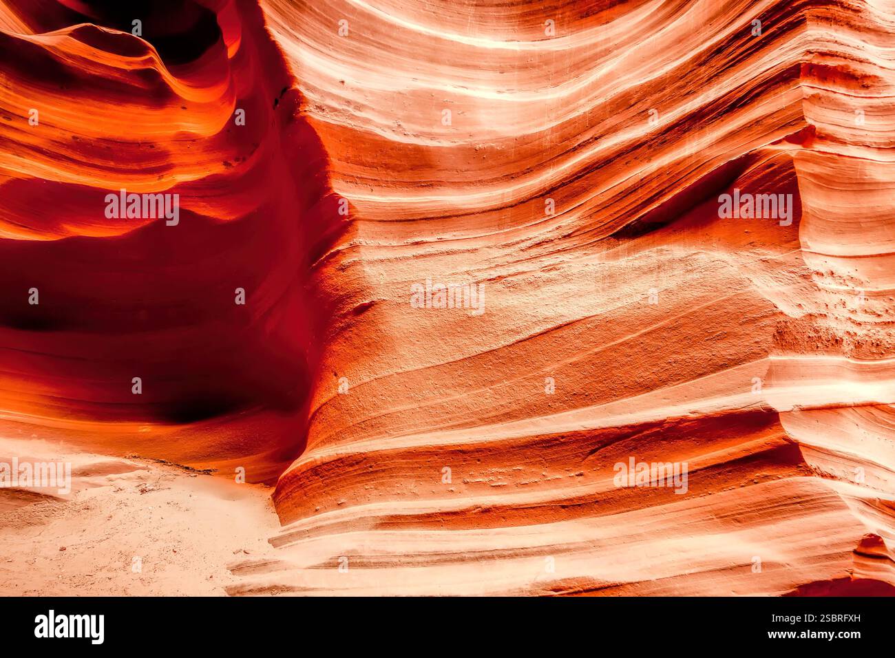 Eine rot-orange Gesteinsformation mit weißer Basis. Die Gesteinsformation ist gekrümmt und hat eine große Textur Stockfoto