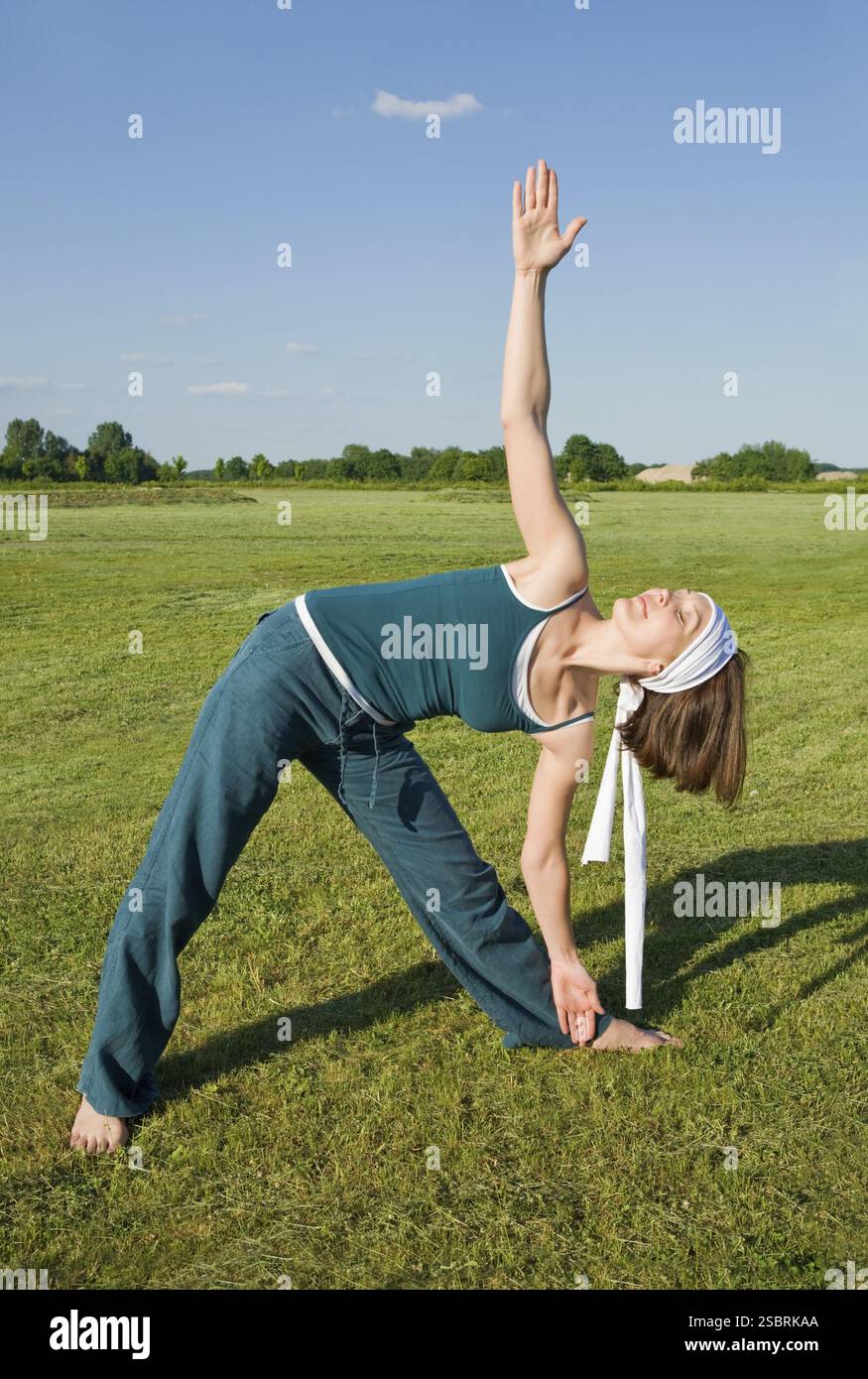 Attraktive Erwachsene Frau, die Yoga-Übungen im Freien macht Stockfoto