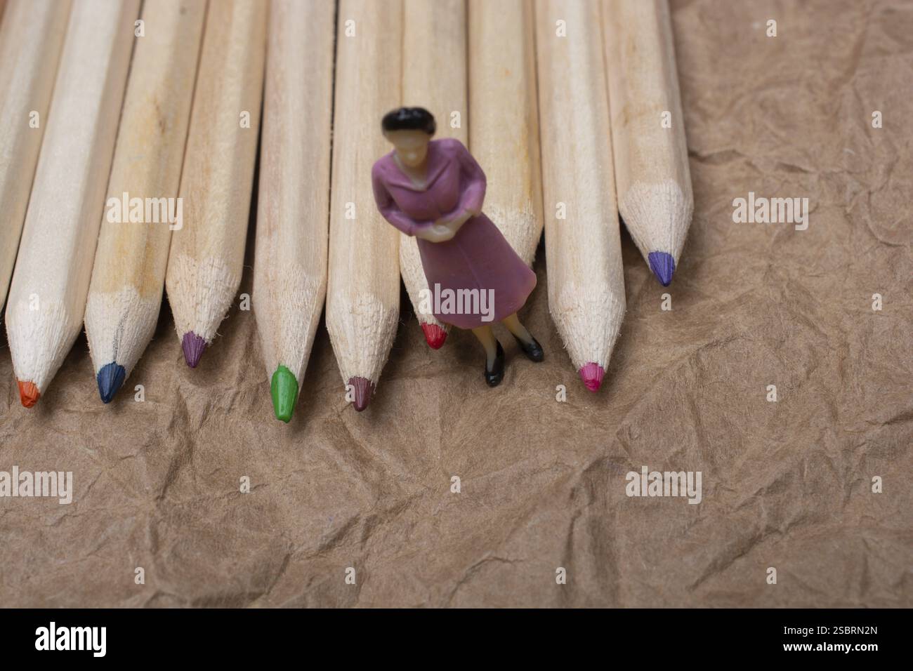 Buntstifte auf Papierhintergrund mit einer Frauenfigur Stockfoto