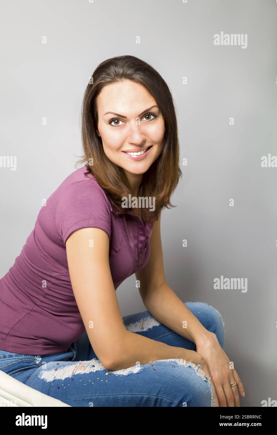 Porträt einer selbstbewussten jungen Frau auf grauem Hintergrund Stockfoto