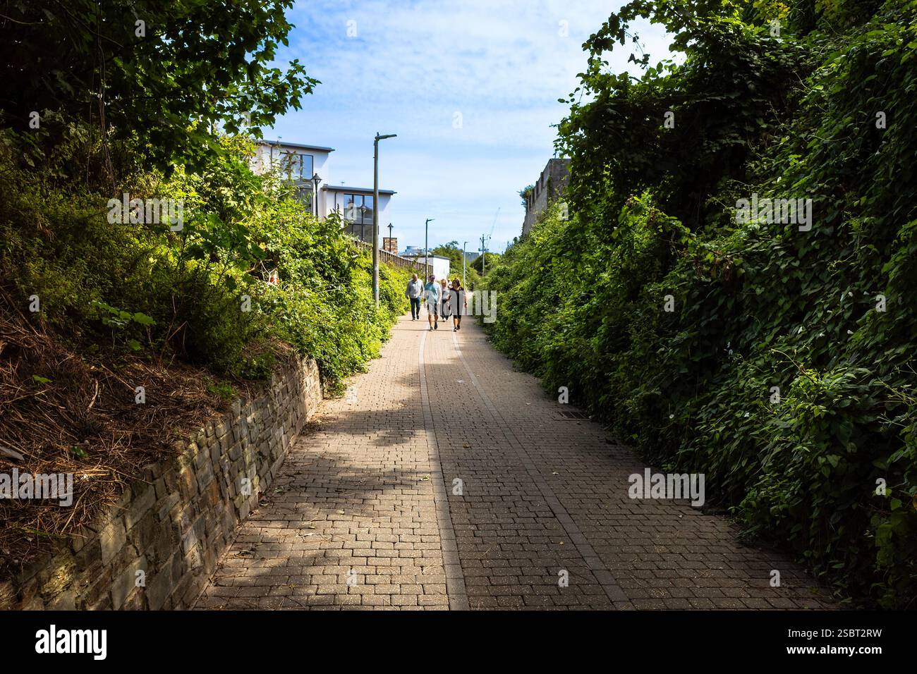 Menschen, die entlang der Fußgängerroute laufen, die als Tram Track bekannt ist. Die Tram Track ist die historische Straßenbahnstrecke, die mit dem Hafen verbunden ist Stockfoto