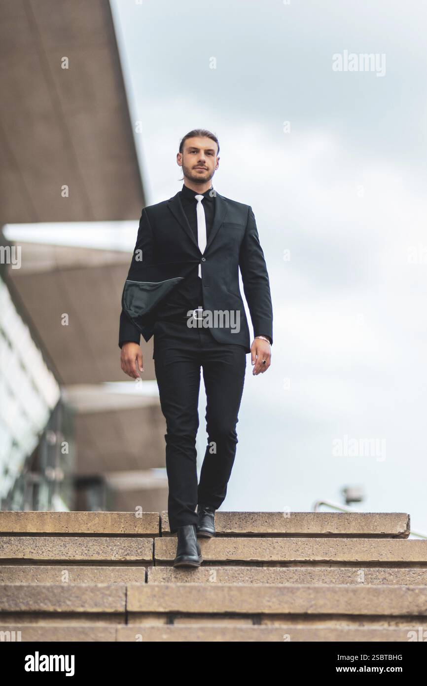 Hübscher, stilvoller junger Geschäftsmann, der im Freien ein Porträt posiert Stockfoto