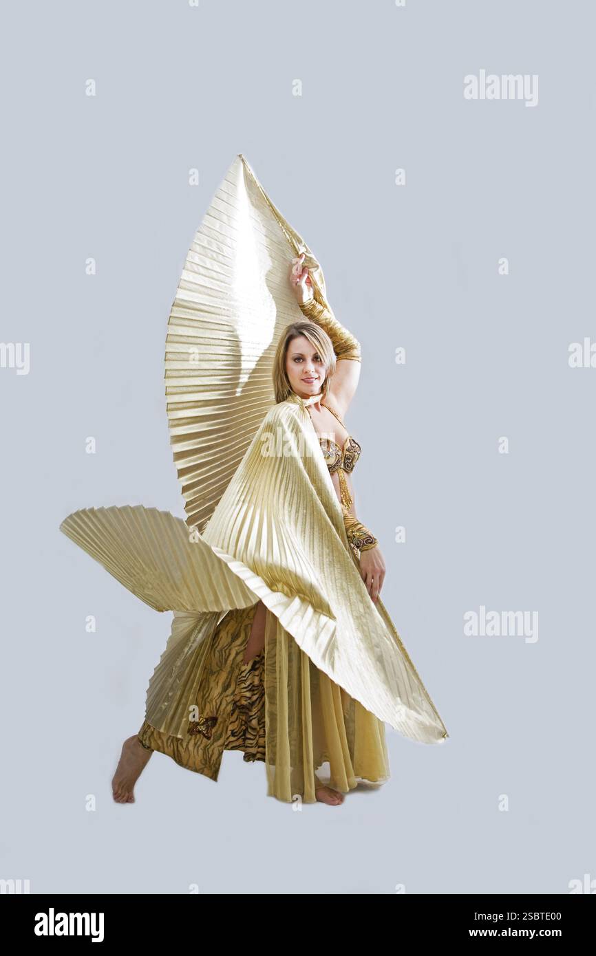 Schöne Bauchtänzerin im goldenen Outfit mit Flügeln, isoliert, New York, USA, Nordamerika Stockfoto