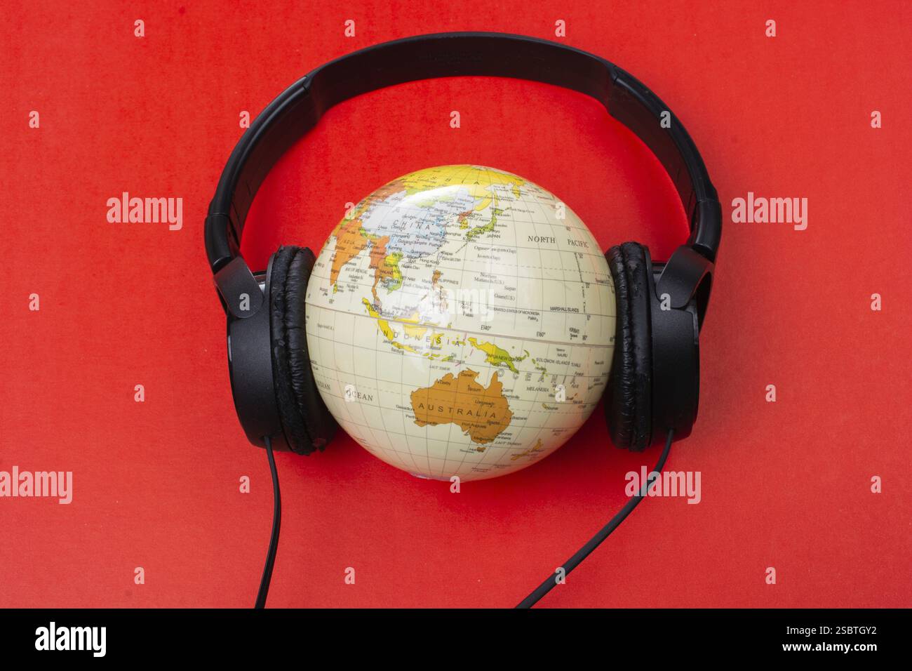 Headset auf Globus isoliert auf dem roten Stockfoto