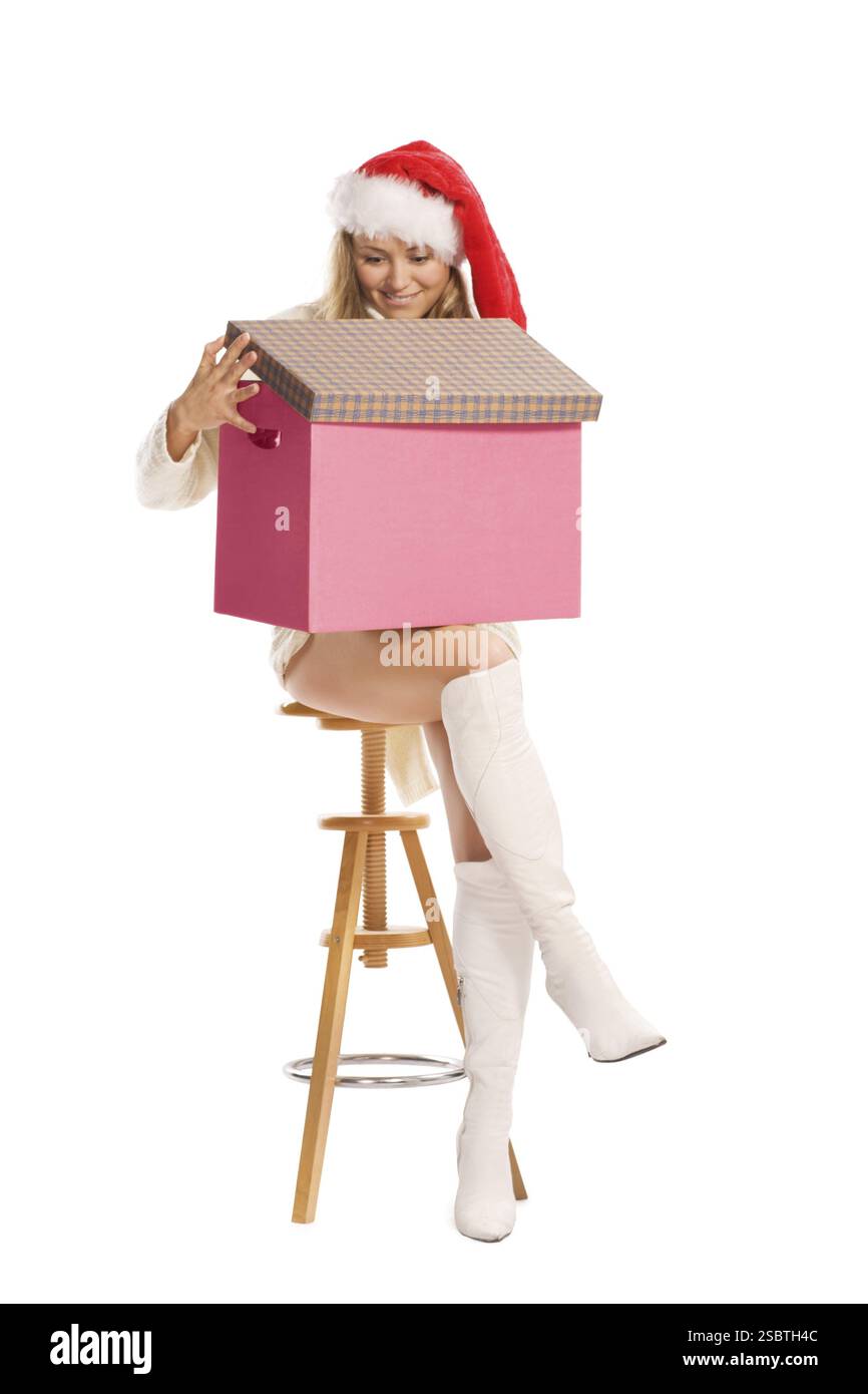 Attraktives Mädchen mit Weihnachtsmann-Hut mit schicker Box, isoliert auf weiß Stockfoto