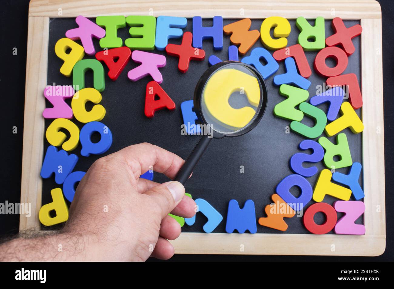 Lupe und bunte Buchstaben des Alphabets Stockfoto