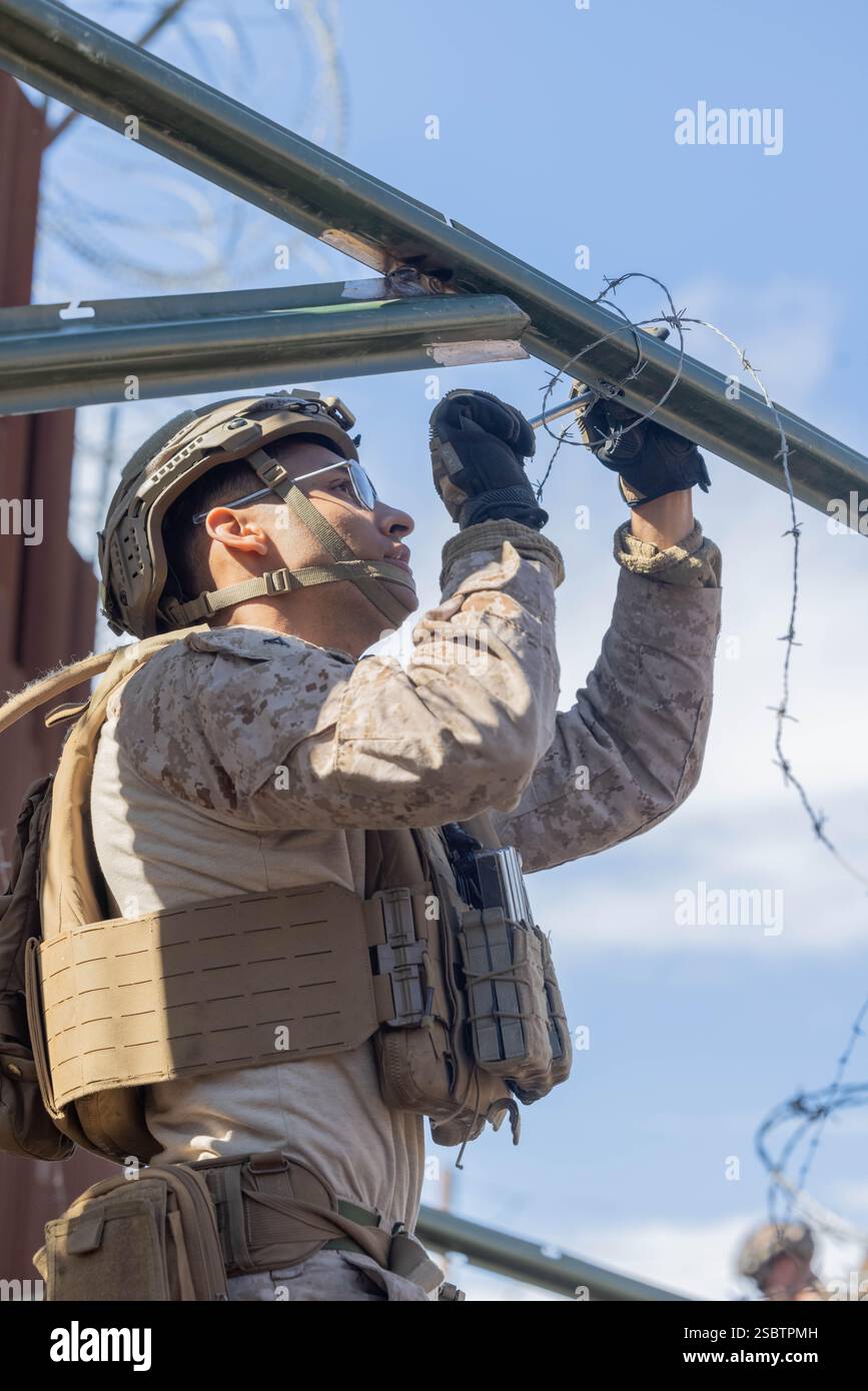 Ein US-Marine mit 1. Kampfingenieur-Bataillon, 1. Marine-Division, justiert Stacheldraht entlang der südlichen Grenzmauer in der Nähe von San Ysidro, Kalifornien, am 3. Februar 2025. Das U.S. Northern Command arbeitet mit dem Department of Homeland Security zusammen, um physische Barrieren zu errichten, um zusätzliche Sicherheit zu schaffen, die illegale Grenzübertritte einschränken wird. (Foto des U.S. Marine Corps von Lance CPL. Caleb Goodwin) Stockfoto