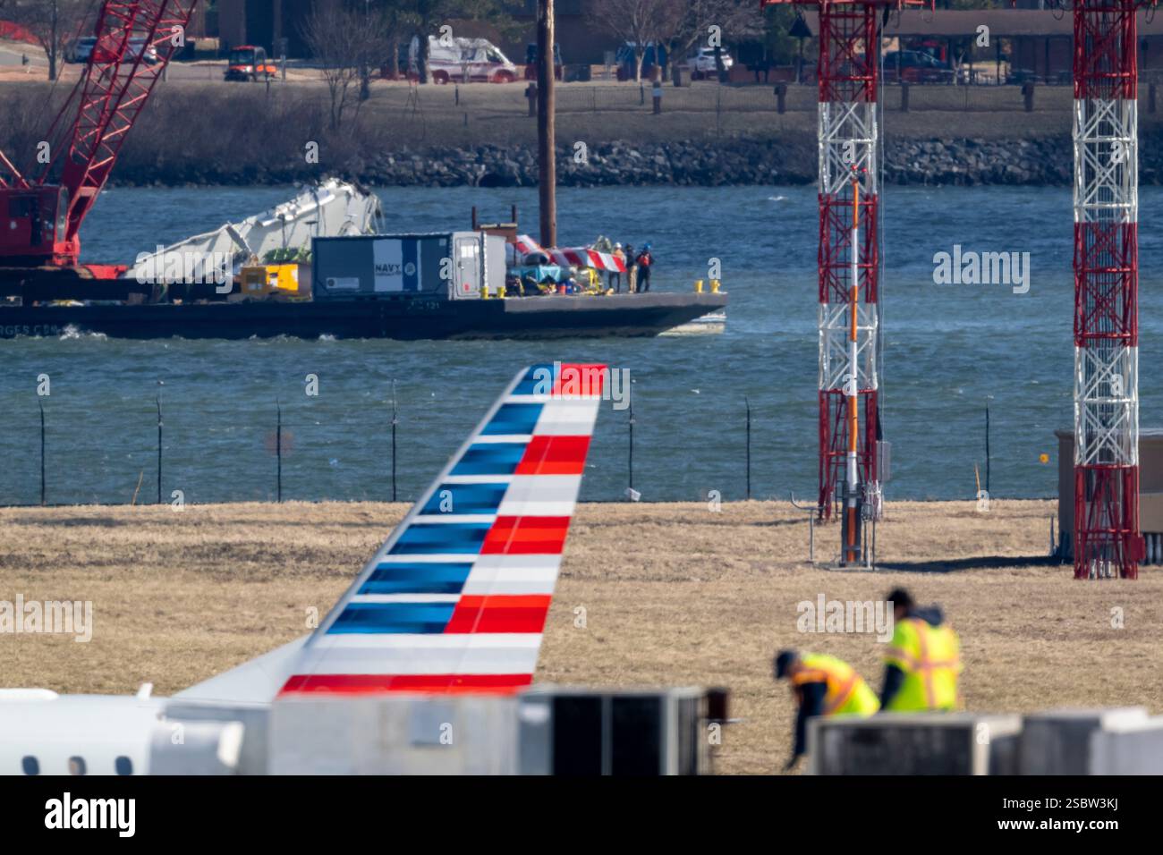 Parts of a plane are lifted from the water near the wreckage site in ...