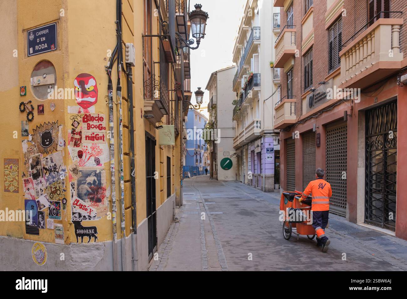 Straßenkehrer in der Altstadt von Valencia. Sie können eine Vielzahl von künstlerischen Straßenkunst an den Wänden der Häuser sehen Stockfoto