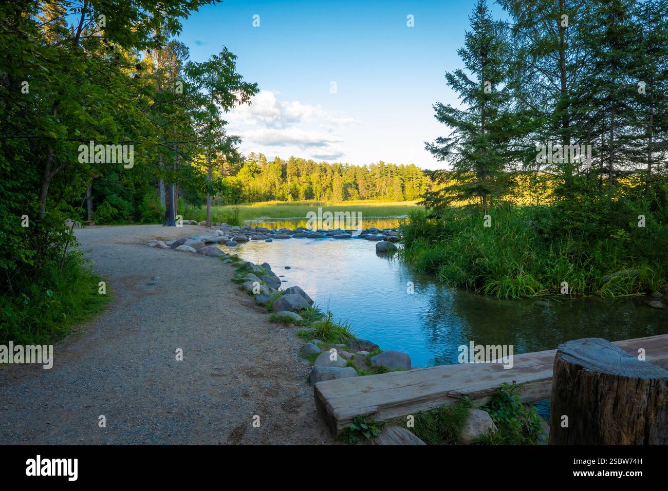 Schotterweg entlang des Mississippi River an seiner Quelle, wo das Wasser aus dem Lake Itasca in Minnesota über einen kleinen Felsdamm fließt. Stockfoto