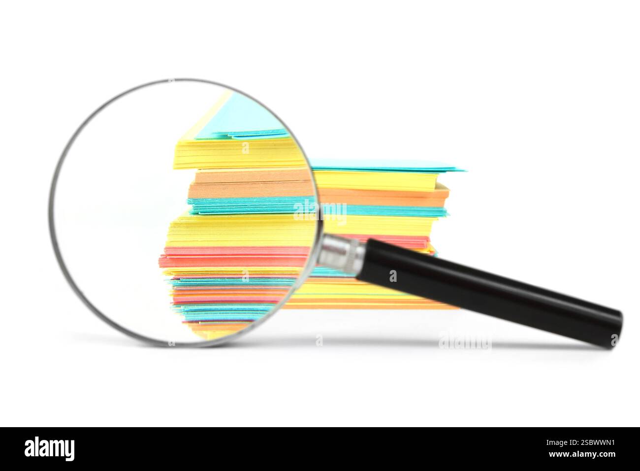 Die Lupe vergrößert den Stapel von Blättern auf weißem Hintergrund Stockfoto