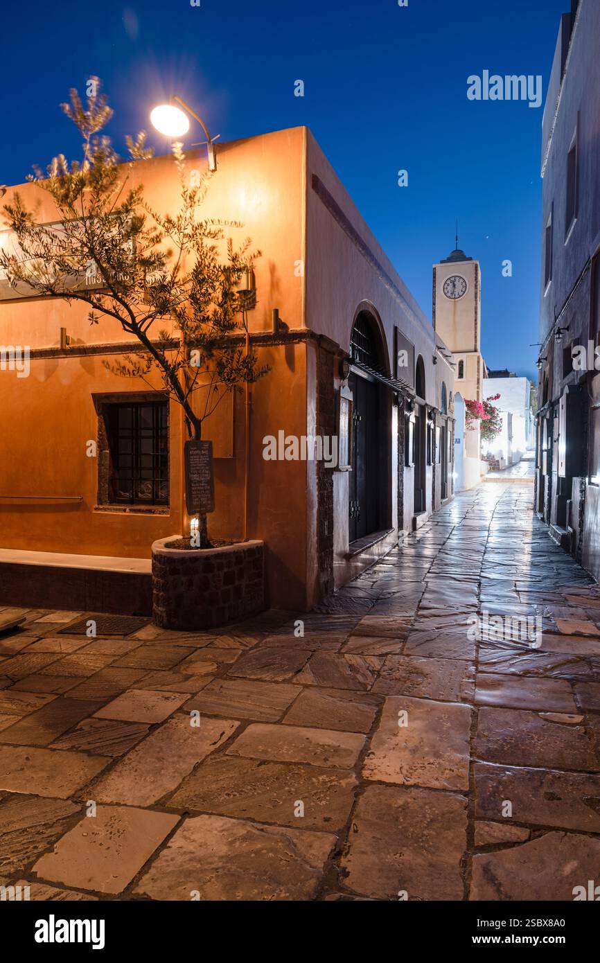 Beleuchtete Gasse mit geschlossenen Bars und Geschäften in der Altstadt von Oia bei Nacht, Santorin, Kykladen, Griechenland Stockfoto